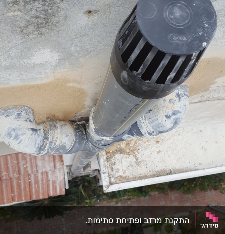 צינור פלסטיק שחור על גג עם לכלוך